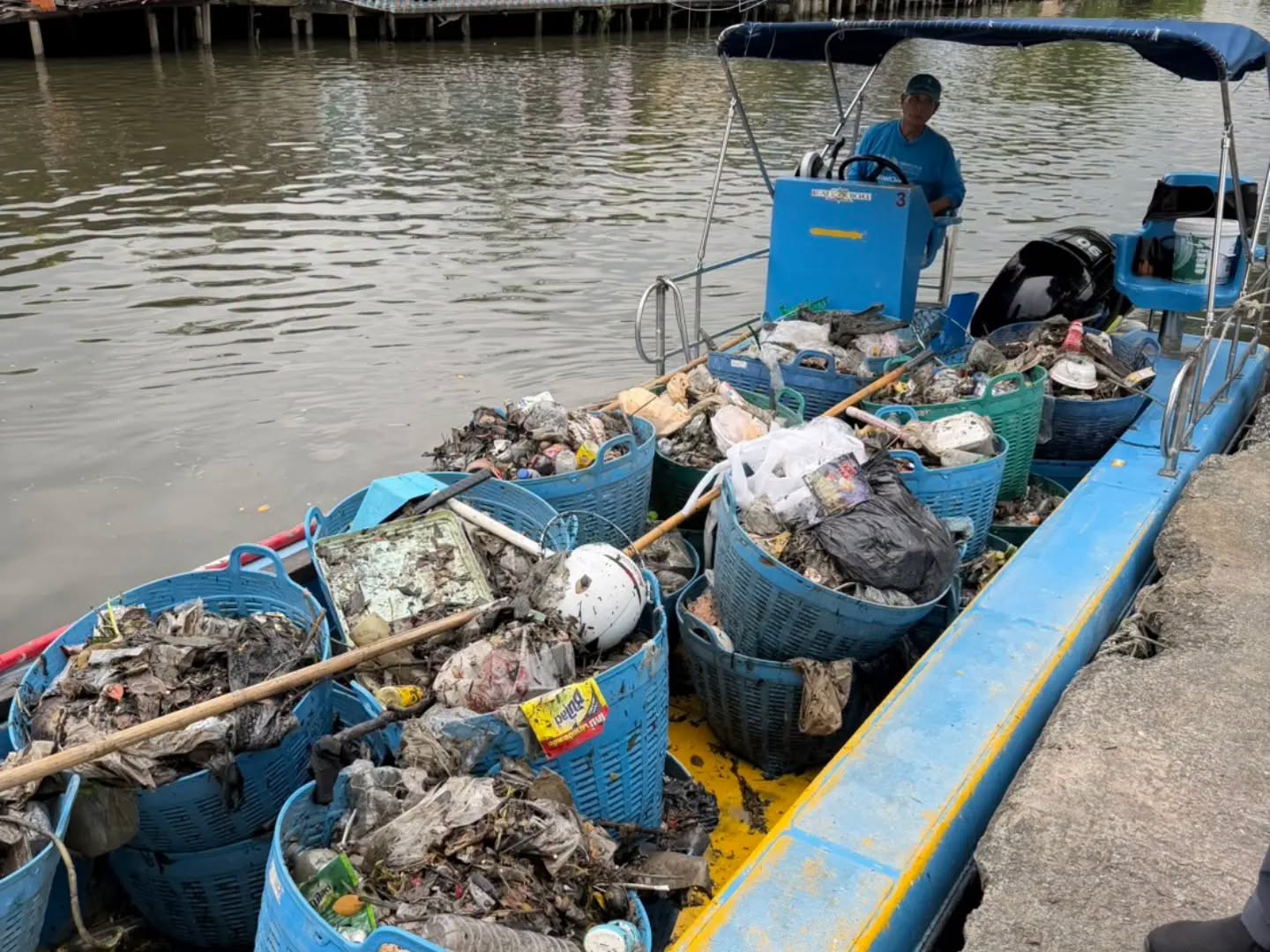 Bateau chargé de bacs de déchets plastiques